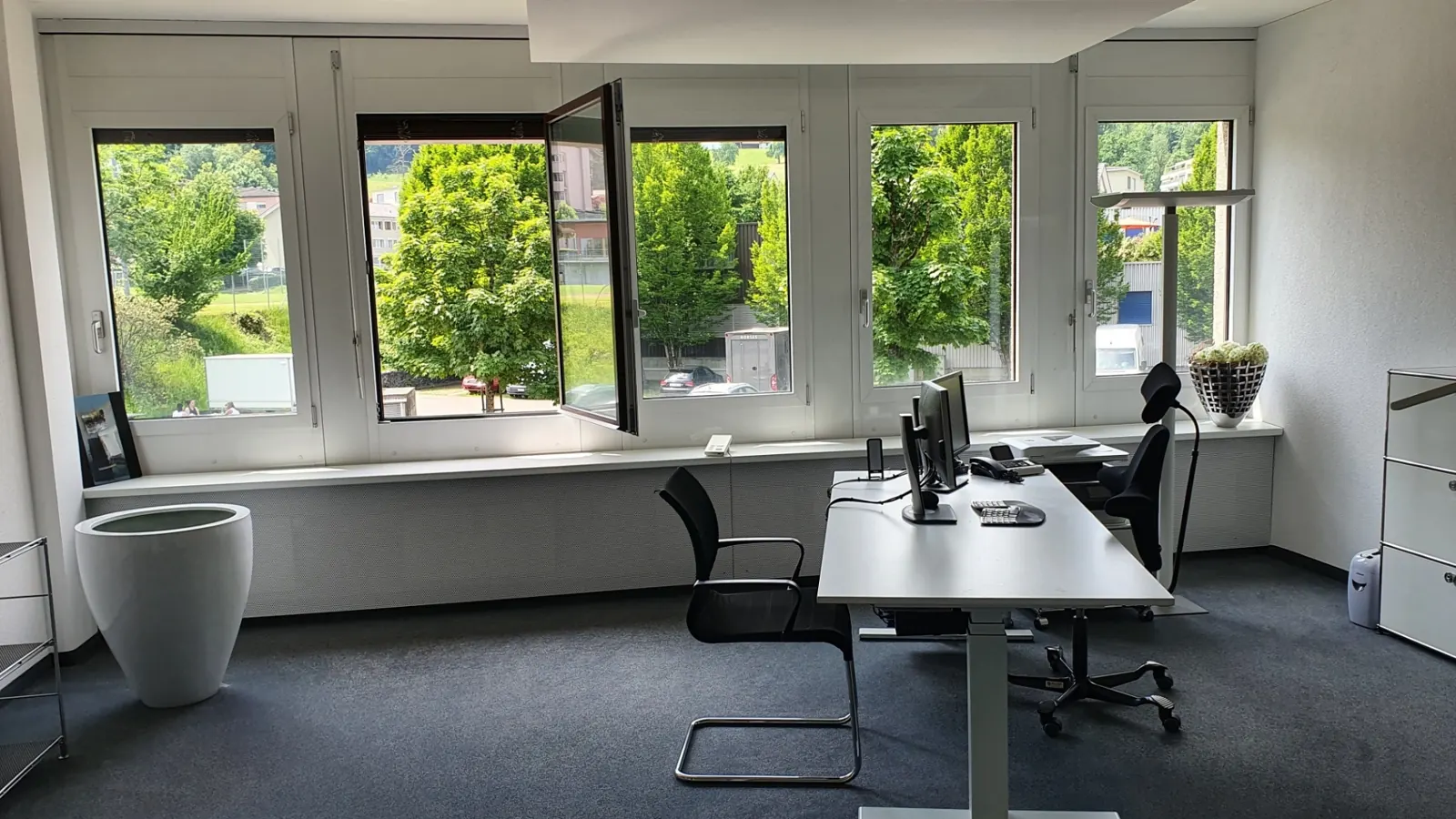 Helles Büro mit Fensterfront ins Grüne